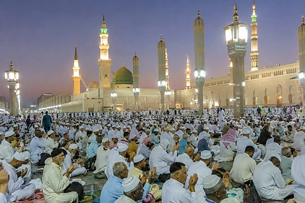 Muslim pilgrims offering dua at Al-Masjid-an-Nabawi in Madinah with the Green Dome during their Umrah pilgrimage in the evening.