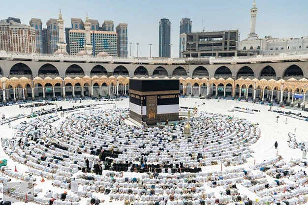 Muslim pilgrims praying around the Kaaba at Masjid al-Haram in Makkah during their Umrah pilgrimage surrounded by the Grand Mosque.