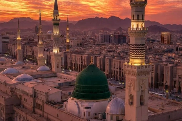 Al Masjid e Nabawi in Madinah featuring the iconic Green Dome and minarets during a beautiful sunset in Saudi Arabia.