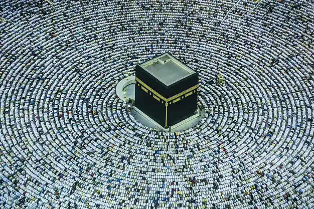 Aerial view of the Holy Kaaba surrounded by pilgrims gathered in concentric rows at Masjid-al-Haram in Makkah.