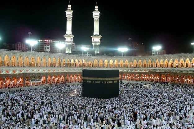 Night view of the Kaaba surrounded by pilgrims performing Tawaf at Masjid-al-Haram in Makkah.