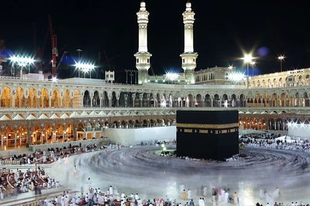Umrah pilgrims performing Tawaf around the Kaaba with a full view of the Grand Mosque in Makkah.
