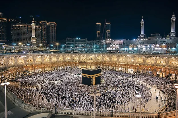Night view of the Holy Kaaba at Masjid Haram surrounded by thousands of pilgrims performing Tawaf