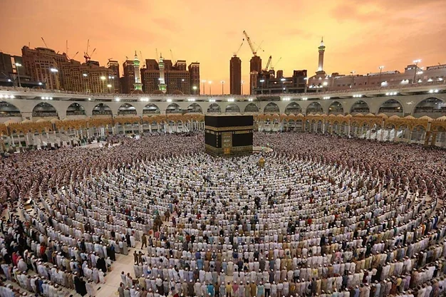 Thousands of pilgrims offering Salah around the Kaaba at Masjid al Haram during sunset in Makkah.