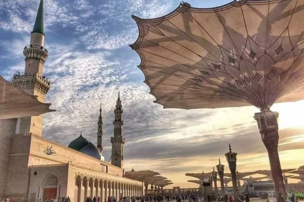 Sunrise view of Al-Masjid an-Nabawi with iconic courtyard umbrellas in Madinah