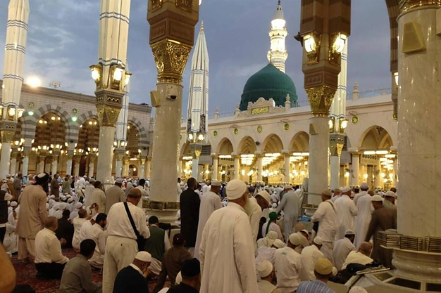 Pilgrims praying in front of the Green Dome at Masjid-e-Nabawi in Madinah during their Umrah journey.