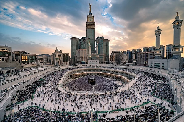Panoramic view of the Kaaba at Masjid-al-Haram with thousands of Muslim pilgrims performing Tawaf beneath the Abraj Al Bait Clock Tower in Makkah, Saudi Arabia.