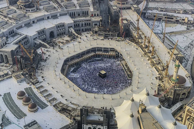 Aerial view of the Holy Kaaba at Masjid-al-Haram in Makkah with thousands of pilgrims gathered for Tawaf and prayer.