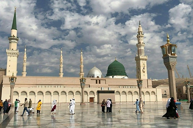 Masjid-e-Nabawi beneath a sky filled with clouds in Madinah, Saudi Arabia.