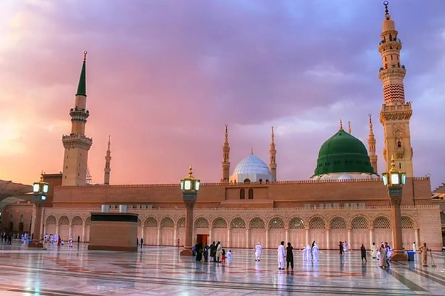 Al Masjid-an-Nabawi in Madinah with the Green Dome at sunset, a sacred destination visited by Muslim pilgrims during Umrah.